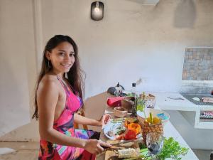 a woman standing in front of a table with a plate of food at On Beach Seaside Sunset Haven 2 - Epic Sea View in Chuburná