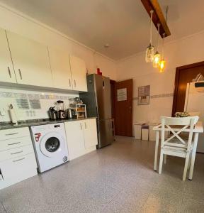 a kitchen with a washing machine and a table at House near Ribeira with Garden, Terrace & Yoga Studio in Santo Isidoro +35 photos