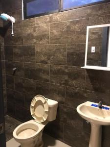 a bathroom with a toilet and a sink at Confortable casa independiente in Crucita +7 photos