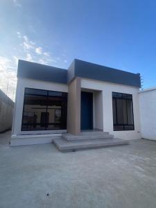 a small white house with a lot of windows at Confortable casa independiente in Crucita