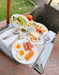 a table with plates of breakfast food on it at BaanPranwadee in Nong Khai