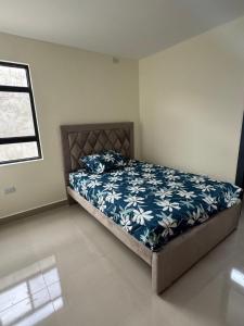 a bedroom with a bed with a blue and white comforter at Confortable casa independiente in Crucita