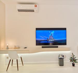 a living room with a tv on a white wall at 22 Macalisterz - King Suite - 65"QLED TV - Disney - Pop Corn - Sky Pool in George Town