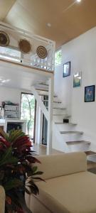 a white staircase in a living room with a couch at Sunny House Homestay in Tam Ðảo