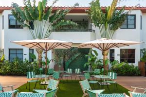 an outdoor patio with tables and chairs and umbrellas at Maison Felix in Miami Beach