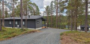 a house with a gravel driveway next to a lake at Hakoranta in Ruka