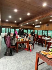a group of people sitting at a table in a restaurant at Lona Villa Tam Coc in Vũ Lâm