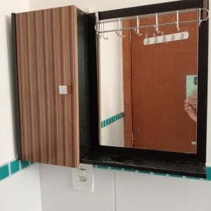 a mirror in a bathroom with a person taking a picture at Enseada Perto da praia Guarujá com vaga de garagem in Guarujá