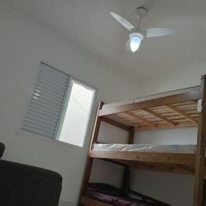 a bedroom with two bunk beds and a ceiling fan at Enseada Perto da praia Guarujá com vaga de garagem in Guarujá