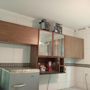 a kitchen with wooden cabinets and a refrigerator at Enseada Perto da praia Guarujá com vaga de garagem in Guarujá