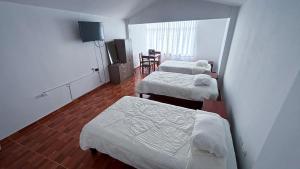 een hotelkamer met 3 bedden en een eetkamer bij Casa Wavve in Huanchaco