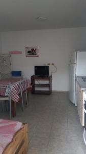 a room with a kitchen with a table and a refrigerator at Flores y limones in Villa Gesell