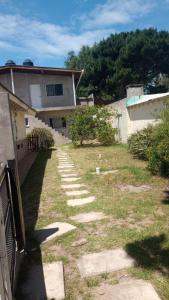 a backyard of a house with a walkway at Flores y limones in Villa Gesell +5 photos