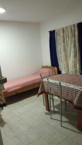 a room with a bed and a table and chairs at Flores y limones in Villa Gesell