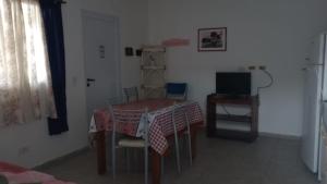 a dining room with a table and a television at Flores y limones in Villa Gesell