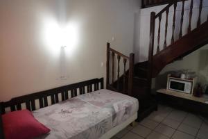 a bedroom with a bed with a microwave on the wall at Camellia 2 Duplex in Sainte-Anne