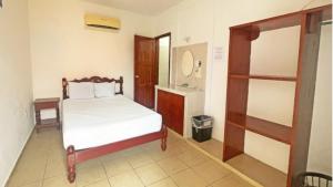 een kleine slaapkamer met een bed en een spiegel bij Hotel Hacienda Bacalar in Bacalar +25 foto's