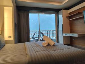 a bedroom with a bed with a view of a balcony at โรงแรม ชาโตว์วิสต้า in Chon Buri +102 photos