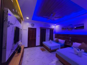 a bedroom with two beds and a blue lighting at Mina Grande Beach Cottages in El Nido