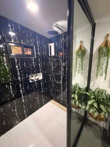 a bathroom with a shower with a black wall at Mina Grande Beach Cottages in El Nido +66 photos