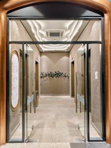 a hallway with a glass door in a building at 22 Macalisterz - King Suite - 65"QLED TV - Disney - Pop Corn - Sky Pool in George Town