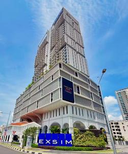 a tall building with a blue sign in front of it at 22 Macalisterz - King Suite - 65"QLED TV - Disney - Pop Corn - Sky Pool in George Town +62 photos