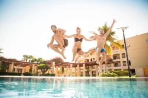 quatro jovens a saltar para uma piscina em Robinson Soma Bay em Hurghada