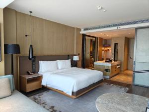 a bedroom with a large white bed and a bathroom at JW Marriott Hotel Taiyuan in Taiyuan