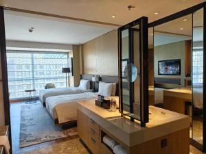 a hotel room with a bed and a mirror at JW Marriott Hotel Taiyuan in Taiyuan