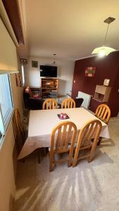 a kitchen with a table and chairs and a living room at Malvinas Casa de Playa in Necochea +2 photos