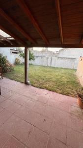 a covered patio with a yard with a concrete wall at Malvinas Casa de Playa in Necochea
