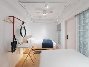 a bedroom with two beds and a desk and a mirror at The Road Mini Hotel in Seoul +79 photos