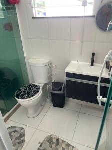 a bathroom with a toilet and a sink at Lareaconchego in São Pedro da Aldeia +6 photos