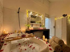 a bathroom with a large bath tub with candles at White Orchid Villa Seminyak in Seminyak