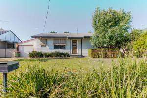 a house with a lawn in front of it at Botanic Base - Designed for Ease & Comfort in Wagga Wagga