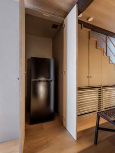 a stainless steel refrigerator in a kitchen with a staircase at Itose Machiya House in Kanazawa