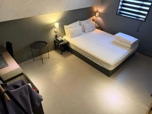 a bedroom with a bed and a table with a stool at 엘루이호텔 in Busan