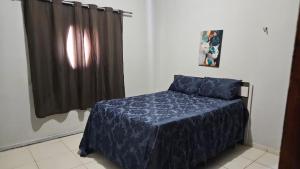 a bedroom with a bed with a blue comforter at Sítio Menezes in Parnaíba