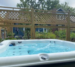 a hot tub in a backyard with a wooden fence at 1890 CapeCod farmhouse:Charming, Private, Spacious in Saugerties