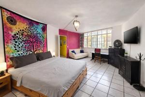 a bedroom with a bed with a painting on the wall at Free Spirit Experience Guadalajara Centro in Guadalajara