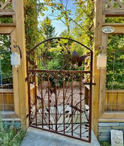 an open gate with a chicken in a garden at 1890 CapeCod farmhouse:Charming, Private, Spacious in Saugerties