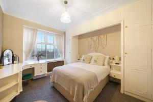a bedroom with a bed and a desk and a window at Spacious Modern 3 Bed Apartment in Hendon NW4 in Colindale
