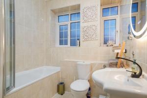 a bathroom with a toilet and a tub and a sink at Spacious Modern 3 Bed Apartment in Hendon NW4 in Colindale +31 photos