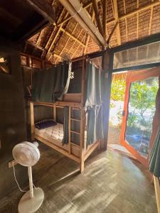 ein Schlafzimmer mit einem Etagenbett in einem Zimmer in der Unterkunft ShakaBrah Beachfront Hostel in General Luna