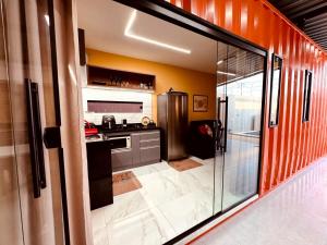 a kitchen with a stainless steel refrigerator in a room at CASA CONTAINER Vsa in Vitória de Santo Antão