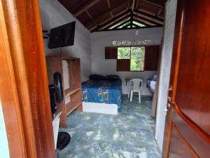 een kleine kamer met een bed en een tv. bij BlueBayou.capurgana in Capurganá