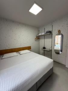 a bedroom with a white bed and a window at Apartamento A03 - Curimã in Passo de Camarajibe +24 photos