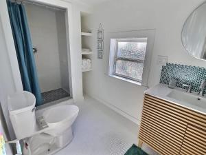 a bathroom with a toilet and a sink and a window at St Augustine Island, King Bed, Beach Living in St. Augustine
