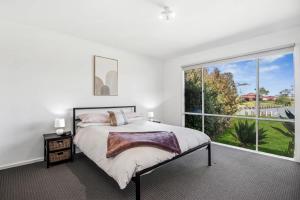 a bedroom with a bed and a large window at Wellington Waters in Wellington East