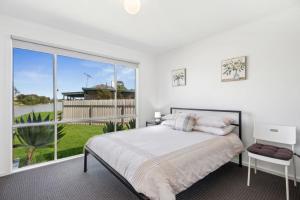 a bedroom with a bed and a large window at Wellington Waters in Wellington East